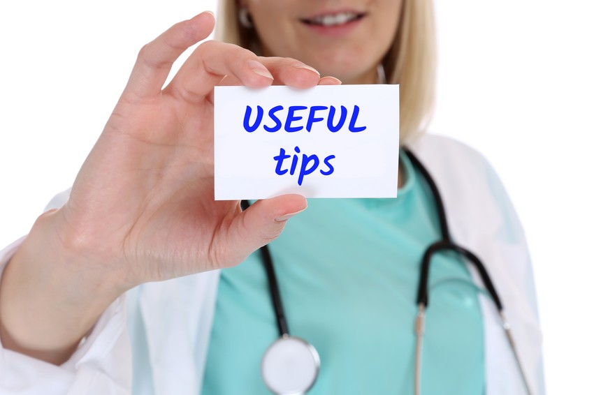 Female medical professional in scrubs holding a card that reads "USEFUL TIPS" for MCCQE1 exam preparation.