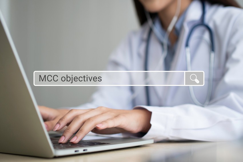 A person in a white coat with a stethoscope types on a laptop. The screen displays a search bar with the text "MCCQE1 exam preparation.