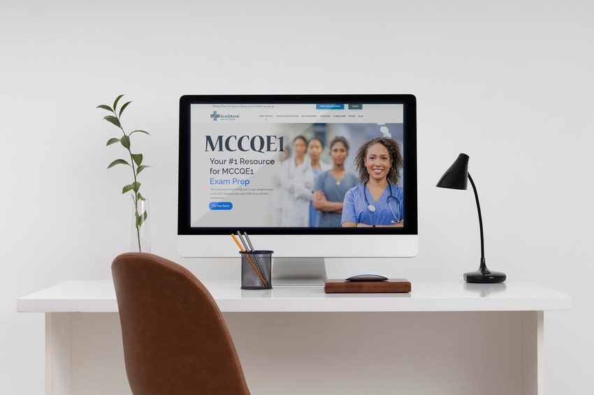 A workspace with a computer displaying Ace QBank for MCCQE1 exam preparation. The desk features a plant, pen holder, lamp, and a brown chair.