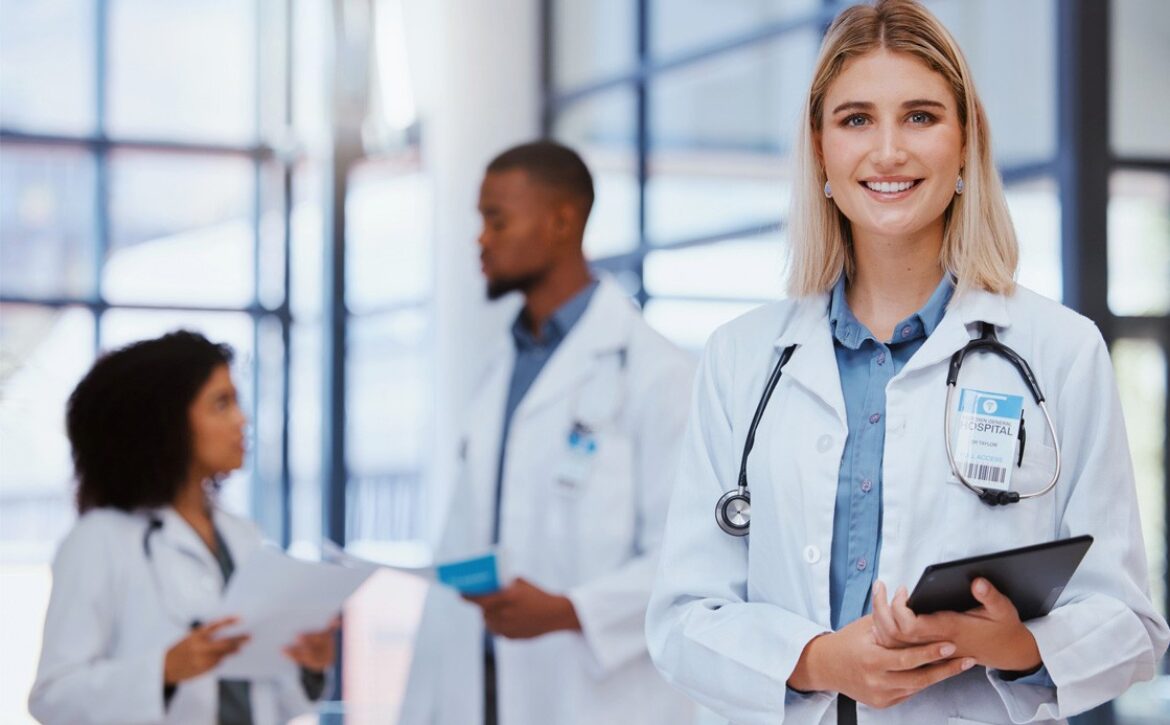 A smiling woman in a white coat holding a tablet stands in the foreground, with two other doctors in white coats discussing the Canadian Medical Licensing Exam pass rate in the background.