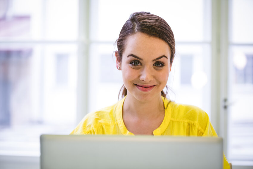 A person is seated at a desk with a notebook nearby, attentively viewing and trying free demo questions on their laptop screen, evaluating Ace QBank for MCCQE1 self-assessment.