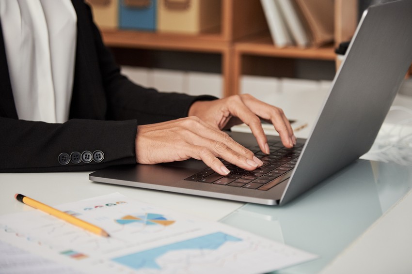 A person is diligently preparing for the MCCQE1 exam, typing on a laptop at a desk surrounded by Ace QBank resources, documents, and a pencil close at hand.