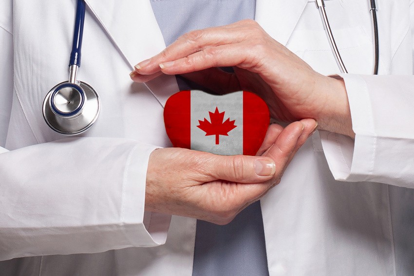 A doctor, ready to ace the MCCQE1 2025, holds a heart-shaped object adorned with the Canadian flag. Dressed in a white coat and stethoscope, they symbolize hope and dedication for IMGs striving to succeed.